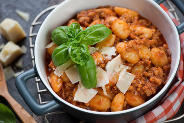 Closeup of potato gnocchi with meat sauce topped with parmesan, selective focus, horizontal shot