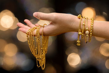 woman hand hold gold bracelet and necklace  jewelry - obrazy, fototapety, plakaty