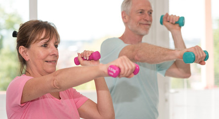 Senior couple exercising with dumbbells