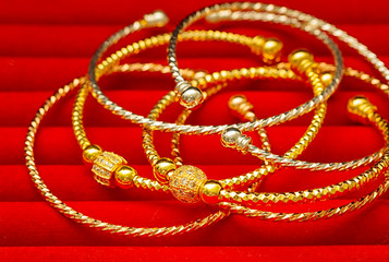 Collection of golden bracelet on red background