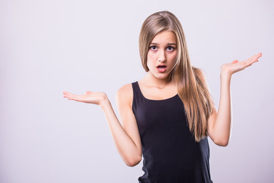 Portrait young woman arms out shrugs shoulders asking isolated grey wall background.