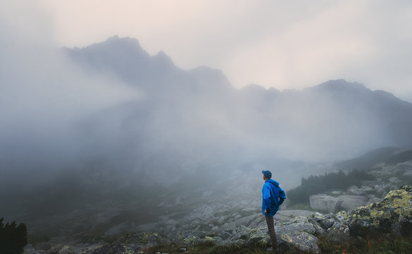 Hiker traveler in foggy mountains