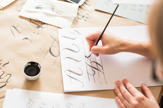 ornamentation, graphic design, education concept. woman preparing writing exercises for learning calligraphy. there is different types of lines and capital letters of russian alphabeth