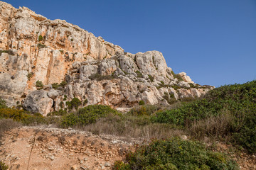 Fototapeta na wymiar Limestone cliff of Southern shore of Malta island. Summer sunny day. Panoramic view.