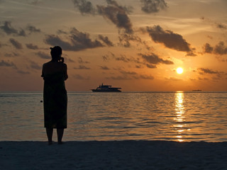 Fototapeta premium Silhouette of woman on the beach at sunset