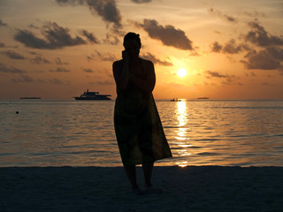 Silhouette of woman on the beach at sunset