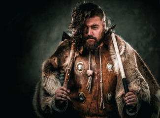 Fototapeta na wymiar Viking with cold weapon in a traditional warrior clothes