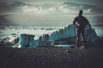 Man explorer lookig at Jokulsarlon lagoon, Iceland. - obrazy, fototapety, plakaty