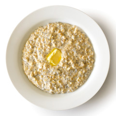 White bowl of oats porridge with chia seeds and butter isolated on white from above.