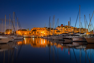 Fototapeta na wymiar Night view of marina with sail boats and yachts and illuminated architecture. Malta island.
