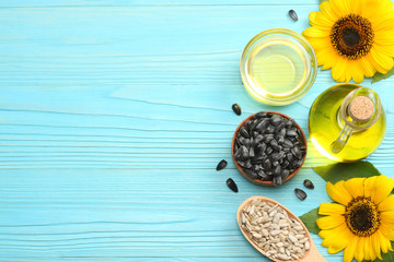 Sunflower oil in glass jug , seeds and flower on blue wooden background. top view with copy space