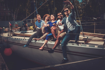 Happy friends taking selfie on a yacht