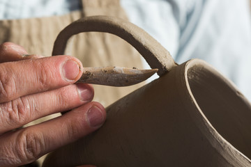 potter, workshop, ceramics art concept - ceramist hands working with unbaked clay product,...