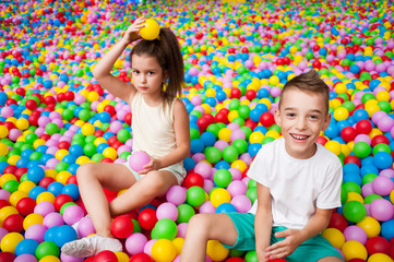 Fototapeta na wymiar Boy and girl playing in colorful balls