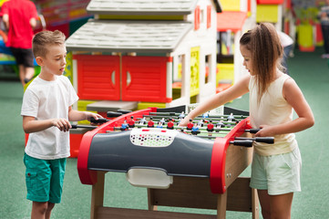 little boy and girl playing table football