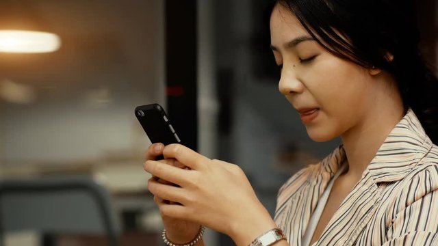 Asian young woman joyfull when chatting with smartphone