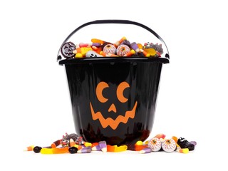 Fototapeta premium Black Halloween Jack o Lantern candy collector with scattered candy over a white background
