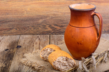 Healthy rustic breakfast. Milk in jug and bread on wooden table