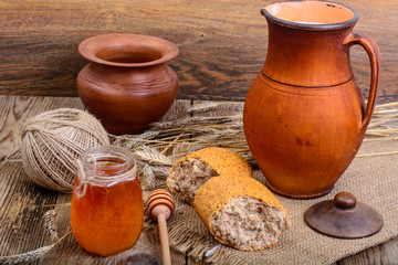 Healthy rustic breakfast. Milk in jug and bread on wooden table