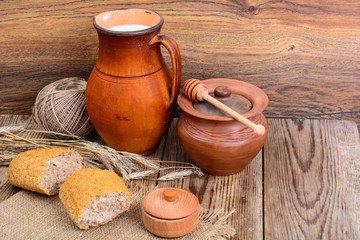 Healthy rustic breakfast. Milk in jug and bread on wooden table