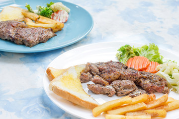 Grilled steak with french fries and vegetables and toast