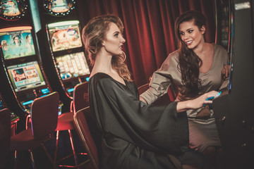 Beautiful women near slots machines in a luxury casino interior