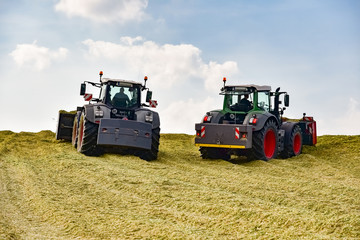 Maisernte für Biogas - zwei Traktoren planieren Maissilage