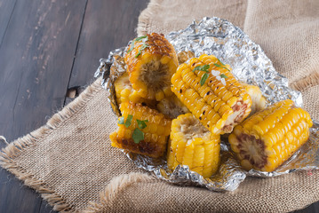 corn grilled on a wooden kitchen board with salt © vimart