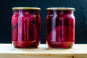 Two cans of canned beets on black background close-up