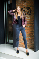 Young Woman standing street lifestyle outdoor on brick wall, fashion