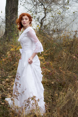 Obraz na płótnie Canvas lady with red hair in vintage white dress in forest
