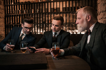 Senior and young gentlemen tasting craft beer