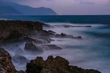 Night rocky shore with smooth water long exposure shot