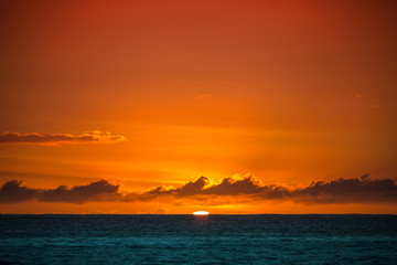 Last sun in ocean. Water surface under red sky