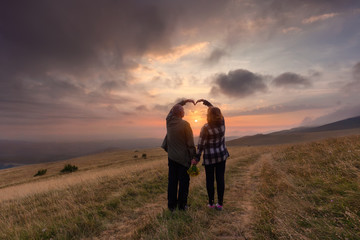 Senior couple in love on mountain at idyllic sunset