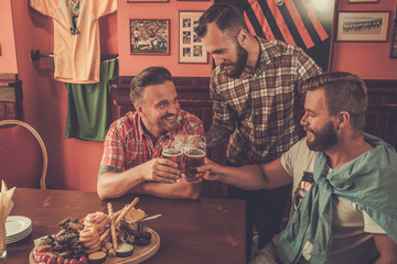Good old friends drinking beer in a pub