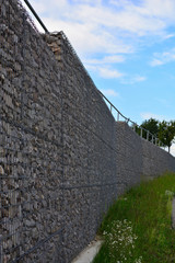 Hohe Mauer aus Metall und Stein