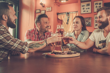 Good old friends drinking beer in a pub