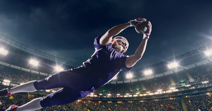 American football player jumps with a ball