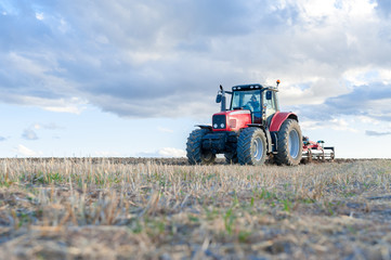 agricultural tractor in the foreground with blue sky background.