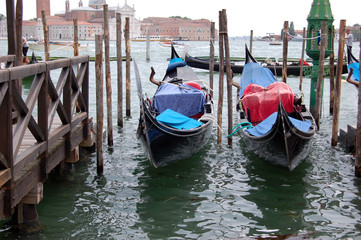 Fototapeta na wymiar two gondolas docked at the pier near San Marco, Venice, Italy