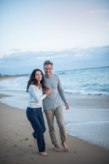  middle-aged couple walking on the beach