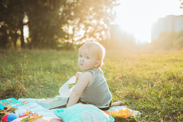 Little adorable baby boy with big brown eyes at sunset summer portrait