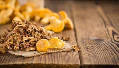 Portion of Dried Chanterelles on wooden background, selective focus