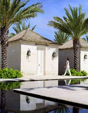 A spa attendant walks into a massage cabana called "Fire" at The Spa at the Palms spa. The Palms resort,Turks and Caicos. British West Indies.