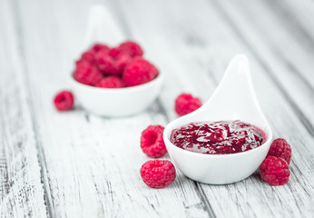 Raspberry Jam on wooden background; selective focus