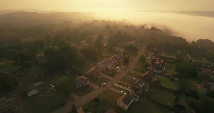 An early foggy morning reverse aerial establishing shot of a typical Western Pennsylvania residential neighborhood. Pittsburgh suburb.	 	