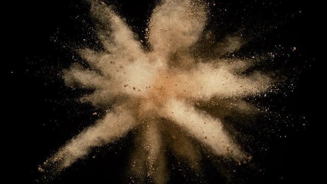 Colorful powder/particles fly after being exploded against black background. Shot with high speed camera, phantom flex 4K. Slow Motion.