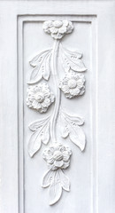 Close up picture background of white flowers bas relief make from plaster on the wall.