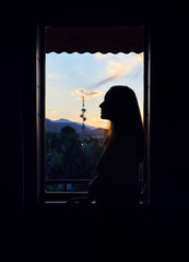 Woman silhouette near window